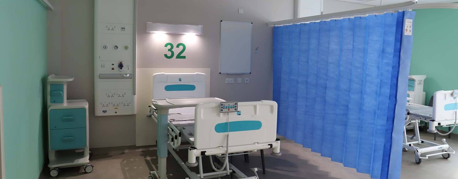 Anti‑ligature curtain track with load‑release mechanism in healthcare setting